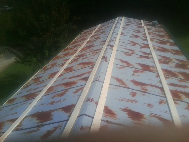 Rusted metal roof panels with new wood purlins before replacement — Storm Damage Roof Repair in Allred by Roofing Brothers