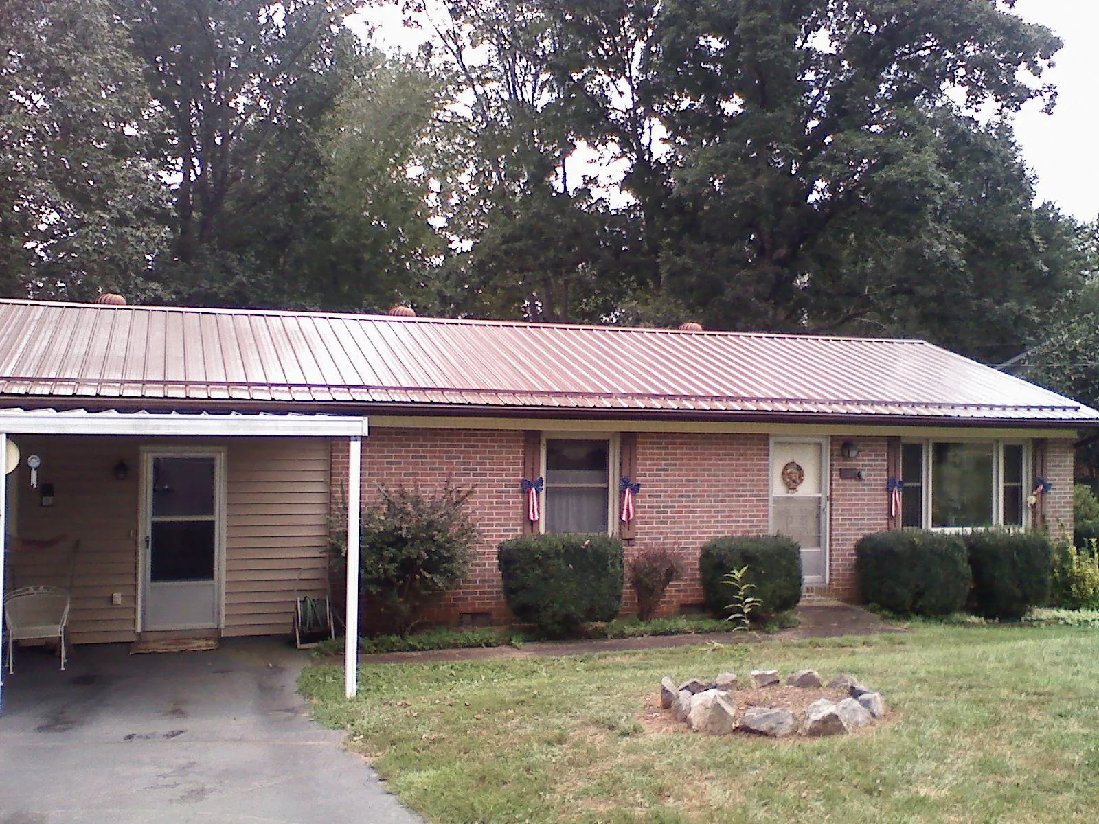 Bronze metal roof and carport on a brick ranch home — Roof Repair work by our crew in Allred