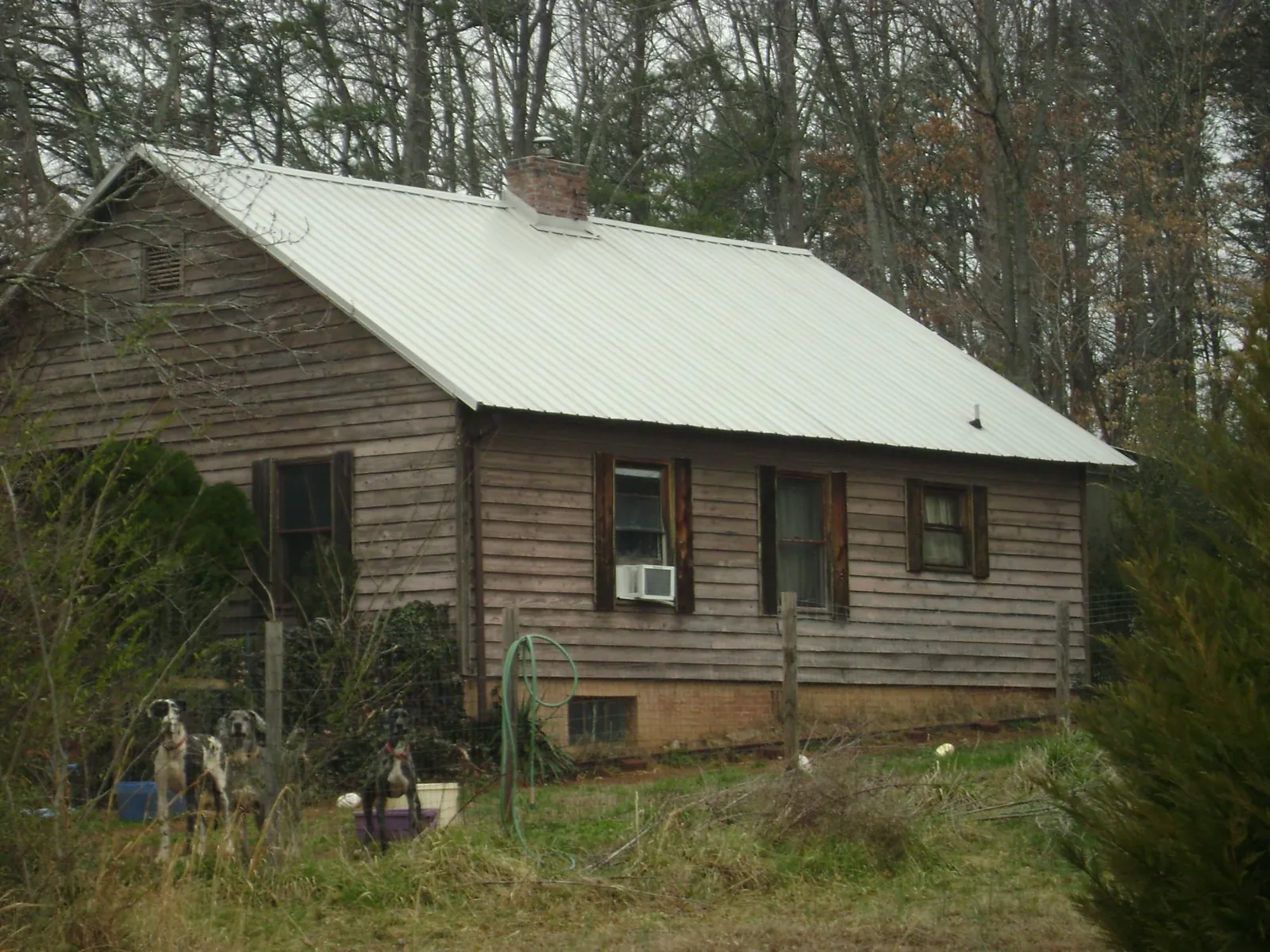 White metal roof on an old wood sided farmhouse, from a Metal Roof Installation job in Allred